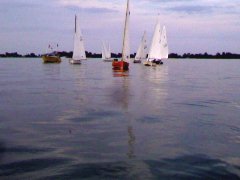 Sailboats becalmed on glassy water